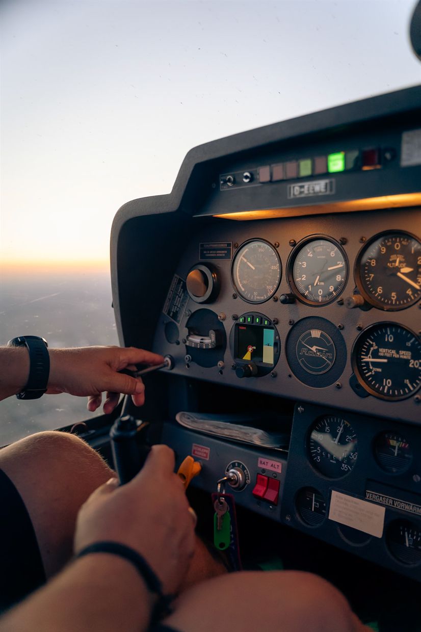 Hände am Steuerknüppel vor den Instrumenten im Cockpit