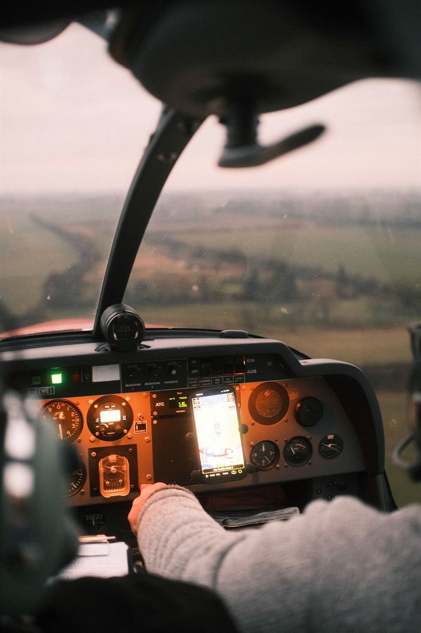 Cockpit mit Instrumenten und Hand am Gashebel im Abendlicht