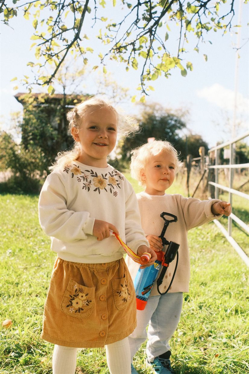 Zwei kleine Kinder auf einer sonnigen Wiese